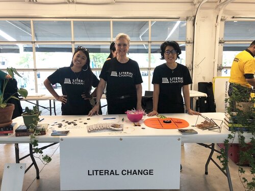 picture of three Literal Change volunteers at a booth